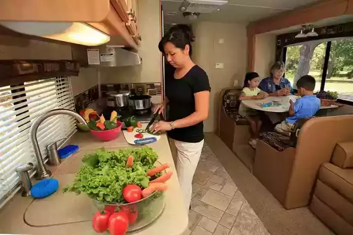 Woman Preparing Meal in an RV Itchen