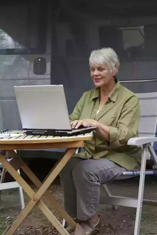 lady outside rv with laptop