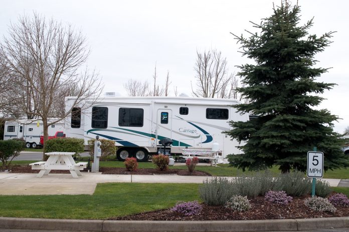and RV in an RV Park, with a well manicured lawn illustrating why you should know How to Invest in RV Parks